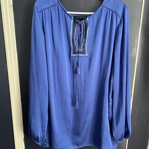 Silky blue top with colorful design and tassels.